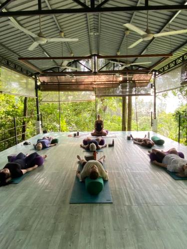 a group of people laying on the floor doing yoga at Ambong Pool Villas - Private Pool in Pantai Cenang