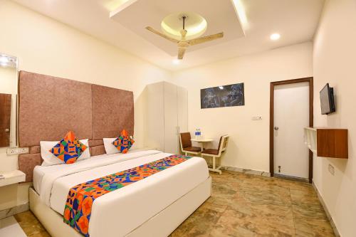 a bedroom with a large bed and a table at FabExpress High View in Faridabad