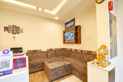a living room with a couch and a tv at FabExpress High View in Faridabad