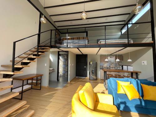 a living room with a blue couch and a loft at Glamping Desierto Santa María 2 in Villa de Leyva