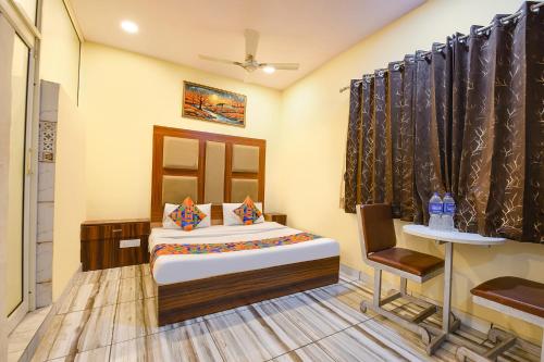 a bedroom with a bed and a table and a chair at FabExpress High View in Faridabad