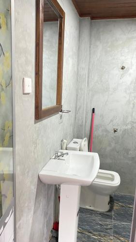 a bathroom with a white sink and a mirror at Mapa Group Rest House in Kurunegala