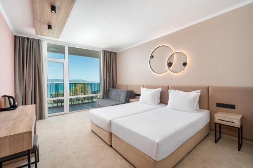 a hotel room with a bed and a large window at Festa Panorama Hotel in Nesebar