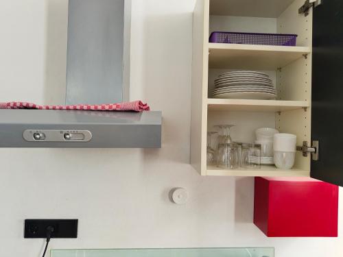 a kitchen cabinet with plates and dishes in it at WHLIVING - Apartments & Studios in Konstanz in Konstanz