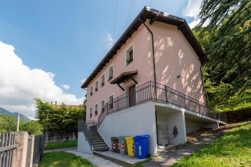 a house with a balcony and stairs on the side at Albergo Diffuso Balcone sul Friuli in Clauzetto