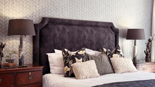 a bedroom with a bed with a black headboard and pillows at Upper Classic in Clarens