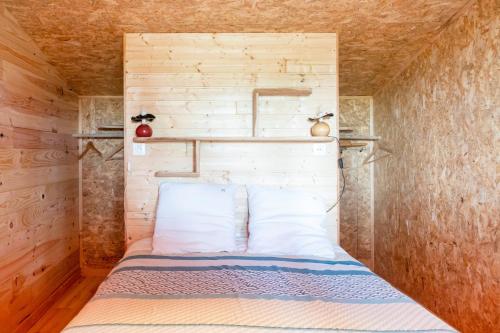 a bed in a small room with a brick wall at L'Escale du Dernier Pin in Escalans