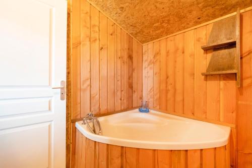 a bathroom with a sink in a wooden wall at L'Escale du Dernier Pin in Escalans