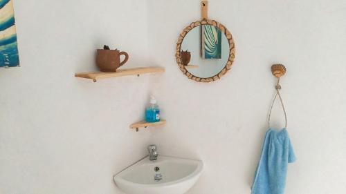 a bathroom with a sink and a mirror on a wall at Idriss Tamraght Surfhostel in Taghazout