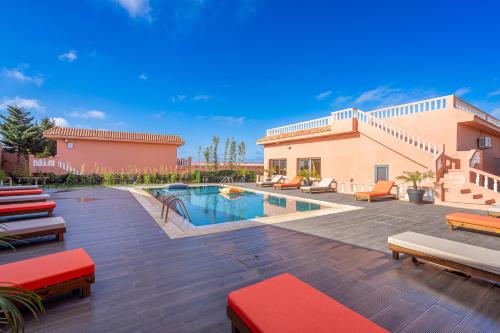 a patio with a pool and chairs and a building at Royal Club Equestre Detroit Bed and Breakfast in Tangier