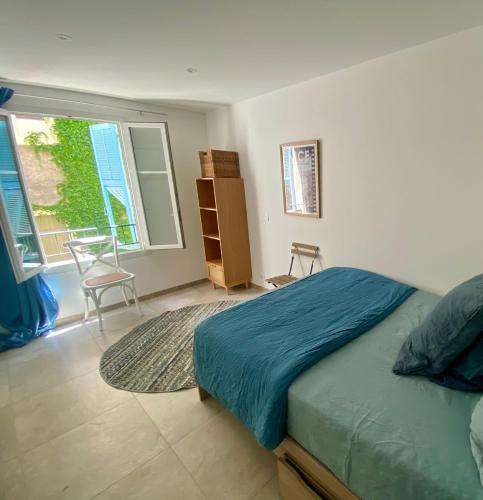 une chambre avec un lit, une fenêtre et une chaise dans l'établissement Au cœur du Vieux Nice, 3 chambres au calme, grand appartement, à Nice