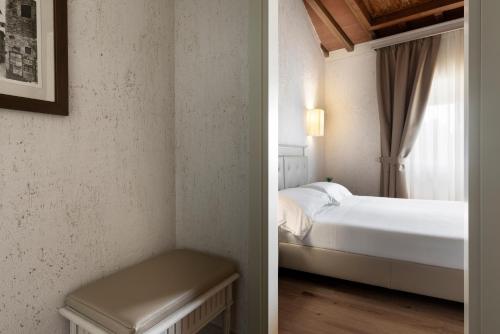 a bedroom with a bed and a table in a room at LHP Hotel Certaldo in Certaldo