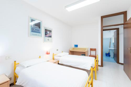 two beds in a room with white walls at Albergo Diffuso Balcone sul Friuli in Clauzetto