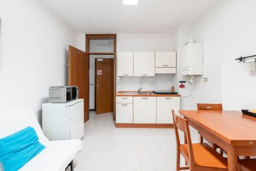 a kitchen with white cabinets and a wooden table at Albergo Diffuso Balcone sul Friuli in Clauzetto