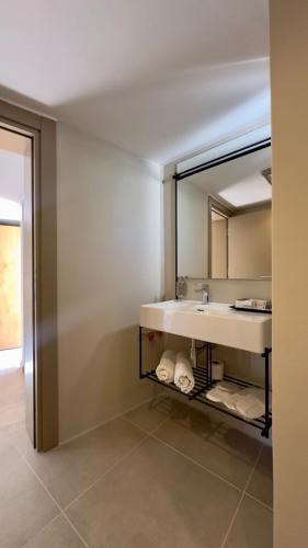 a bathroom with a sink and a mirror at Mercans Bodrum Beach Hotel in Bodrum City