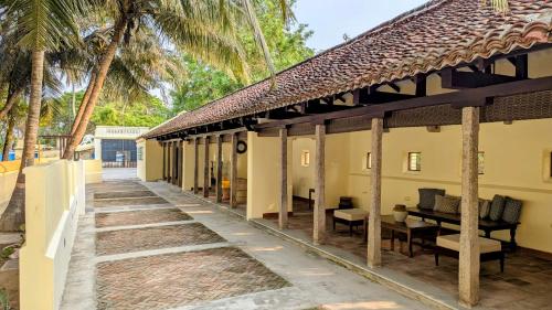 un edificio con una pasarela junto a palmeras en Shruti by Luxunlock Private Villas, en Nannilam