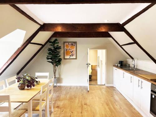 a kitchen and dining room with a table in a attic at Carleys Yard by The Suffolk Cottage Collection in Framlingham