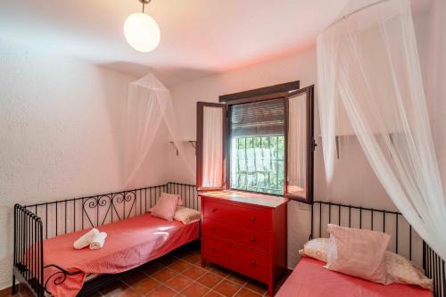 ein kleines Schlafzimmer mit zwei Betten und einem Fenster in der Unterkunft Casa Rural Carula in La Puebla de Cazalla