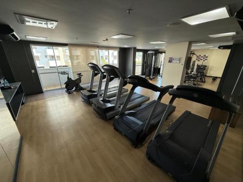 a gym with treadmills and a row of exercise bikes at Flat Studio Conforto do 9 Andar in Nova Iguaçu