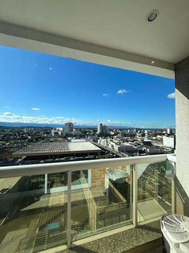 a large glass balcony with a view of a city at Flat Studio Conforto do 9 Andar in Nova Iguaçu