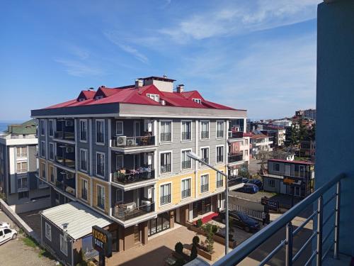 un edificio con techo rojo en una calle de la ciudad en gökçedeniz apartment, en Trabzon
