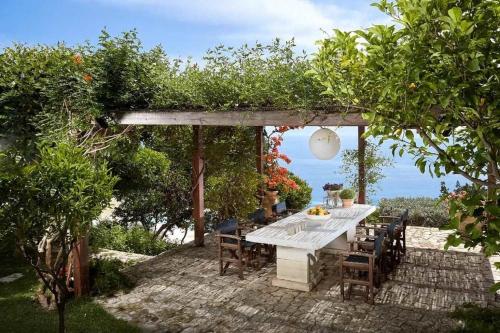 a white table and chairs under a pergola at Villa Vollard Panoramic Seaview & Private Pool in Rodia