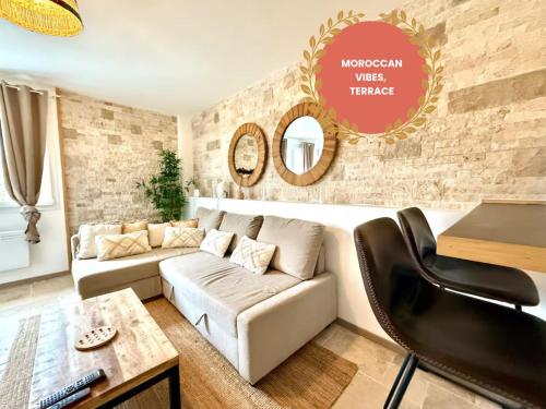 a living room with a white couch and a brick wall at Le Essaouira - Gare Bellegarde - Direct Genève in Bellegarde-sur-Valserine