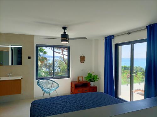 une chambre avec un lit bleu et une grande fenêtre dans l'établissement Villa d'Exception à 20m Des Sablettes Plage, Côte d'Azur, à La Seyne-sur-Mer