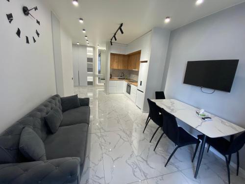 a living room with a couch and a table at A&M Apartments White - New Building in Yerevan