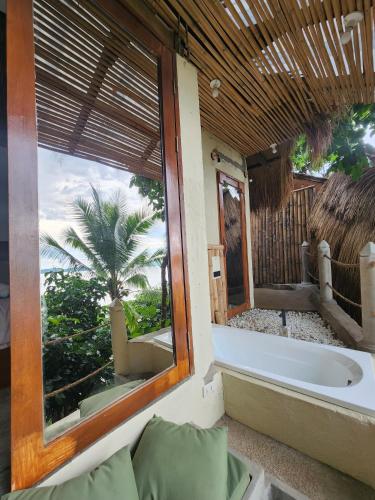 a bath tub in a room with a window at Cocovana Beach Resort in Busuanga