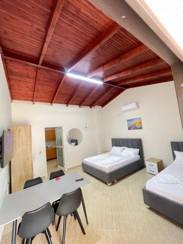 a bedroom with a bed and a table and chairs at Dori Apartment in Vlorë