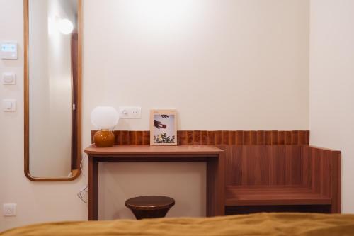 a bed room with a table and a mirror at LALA Hôtel in Paris