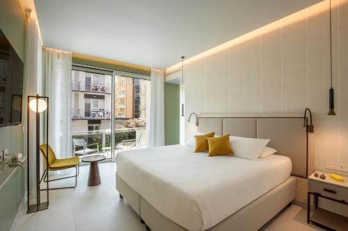 a bedroom with a large bed and a balcony at Ambasciatori Suite Hotel in Sottomarina