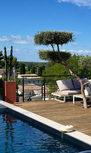 - une piscine avec une terrasse en bois à côté d'une piscine dans l'établissement La villa sitta, à Gallargues-le-Montueux