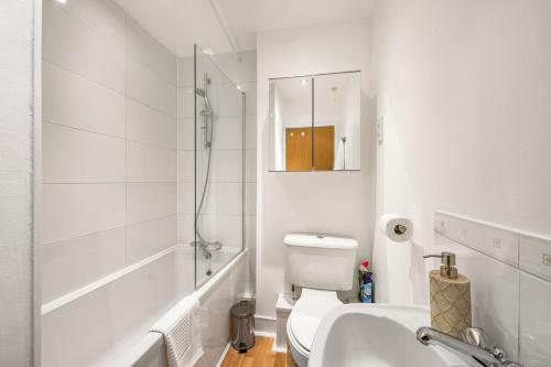 a white bathroom with a toilet and a sink at 3 Bed Townhouse I Secure Parking I Sleeps 9 in Ipswich