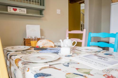 a table with plates and a tea pot on it at The Hayloft Boundary Farm, Framlingham in Woodbridge