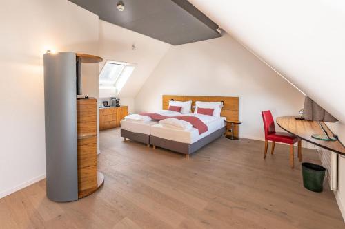 a bedroom with a bed in a attic at Tailormade Hotel KRONE Sarnen in Sarnen
