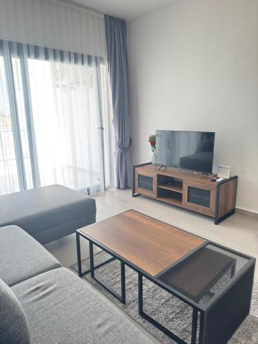 a living room with a couch and a tv at Caesar Resort & SPA - Rahat & Konforlu Daireler in Iskele