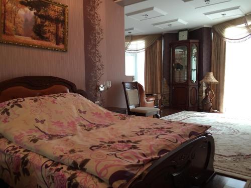 a bedroom with a bed and a chair in it at Hotel Oktan in Kryve Ozero