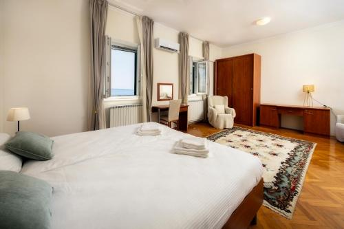 a bedroom with a large white bed and a chair at Villa Mediteran in Split