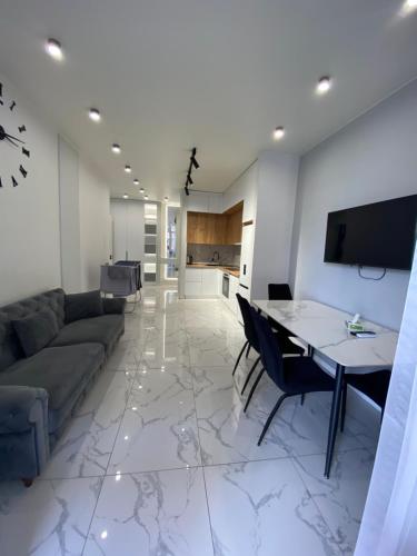 a living room with a couch and a table at A&M Apartments White - New Building in Yerevan