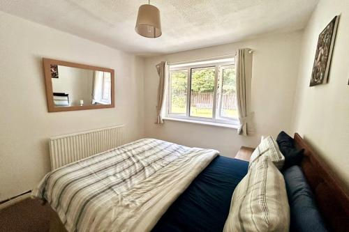 a bedroom with a bed and a window at Oldham Bungalow Retreat: 2BD Peaceful Comfort in Lees