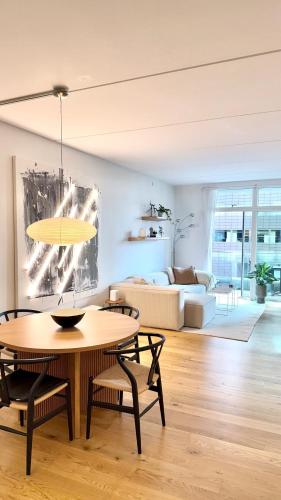 a living room with a table and a couch at Heart of Aarhus, modern apartment and paid parking nearby in Aarhus