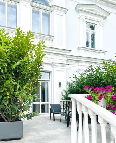 a white building with some plants and flowers at Villa Romana Apartments in Baden
