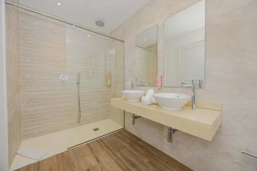 ein Badezimmer mit zwei Waschbecken und einer Dusche in der Unterkunft Villa Jade II in Can Picafort