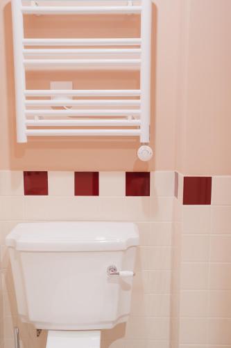 a bathroom with a toilet with a window above it at LALA Hôtel in Paris