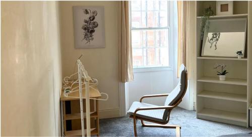 a room with a chair and a table and a window at Edinburgh Central Cozy Flat in Edinburgh