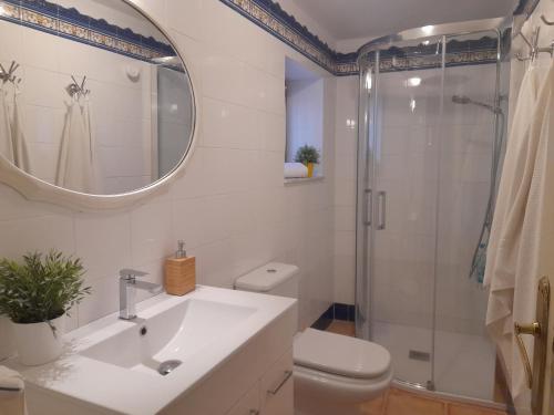 a white bathroom with a sink and a shower at Casa Cotiellu in Llanes