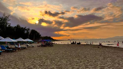 a beach with umbrellas and people on the sand at Private 4 bedrooom Nongnia Beach Villas in Tân Thành (1)