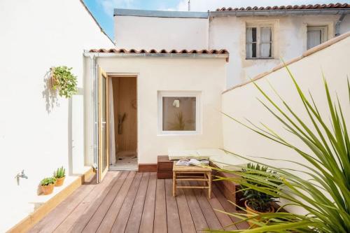 une terrasse avec un banc sur une maison dans l'établissement Appartement au cœur de La Rochelle avec terrasse, à La Rochelle